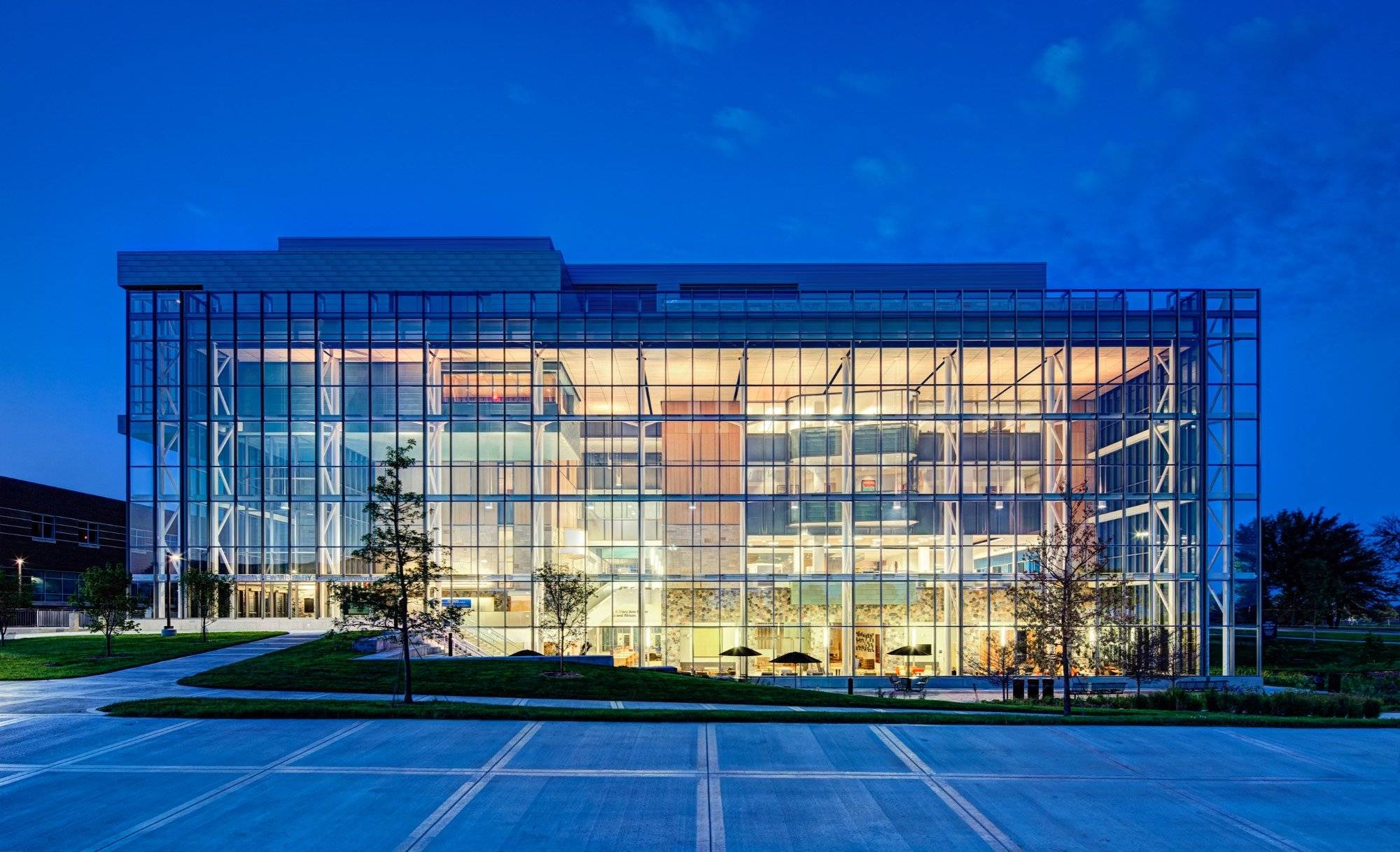 Mary Idema Pew library lit up at night with a glowing wall of windows